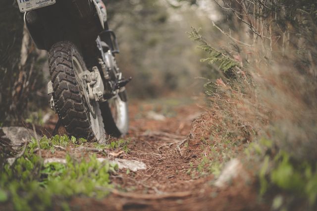 An adventure motorcycle crossing a shallow river ford on a byway in the Cambrian Mountains of Wales.