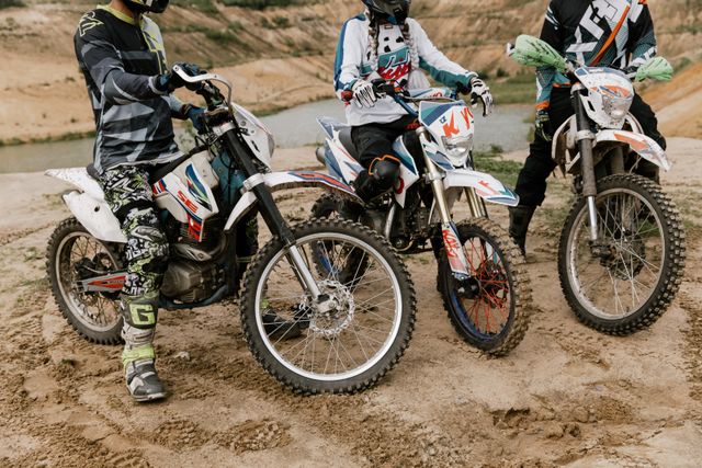Three riders on adventure motorcycles pausing on a rocky quarry-like track
