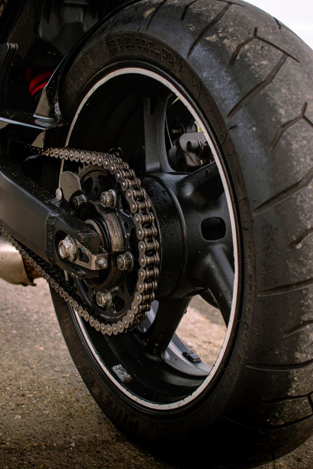 Close-up of a motorcycle's rear chain and wheel