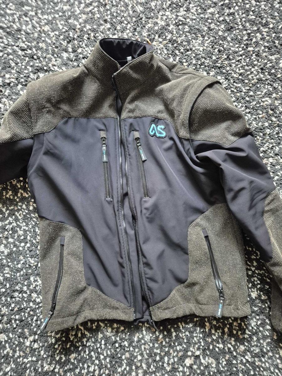 The Adventure Spec Linesman jacket laid flat, front view, in grey and navy softshell