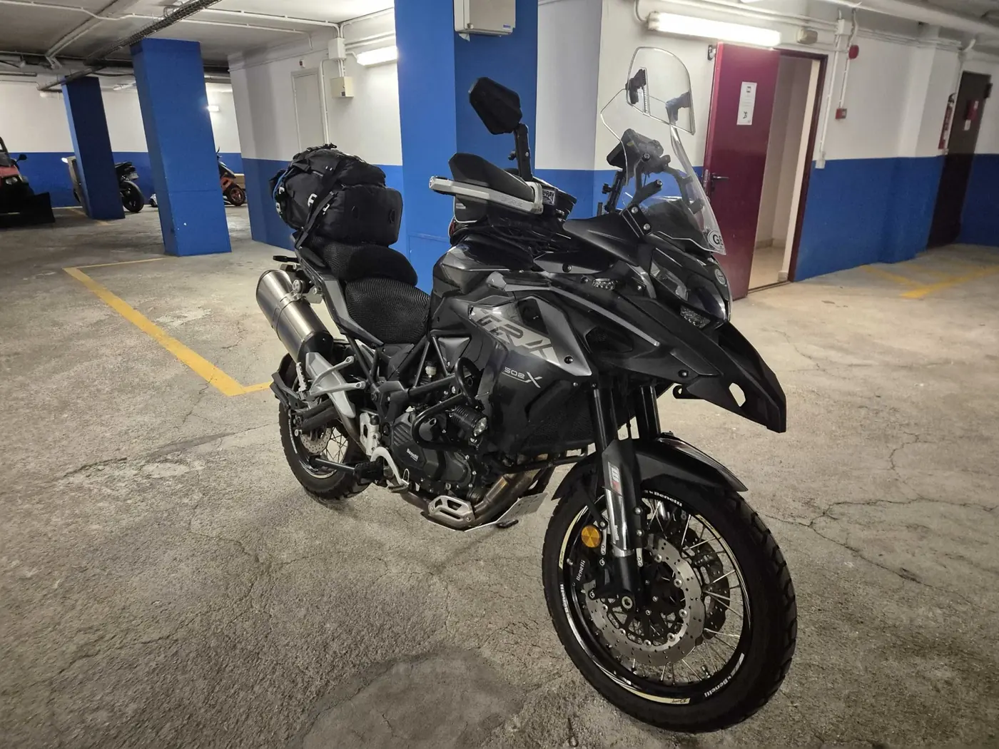 Benelli TRK 502X front three-quarter view showing the twin front discs, spoked front wheel and crash bars