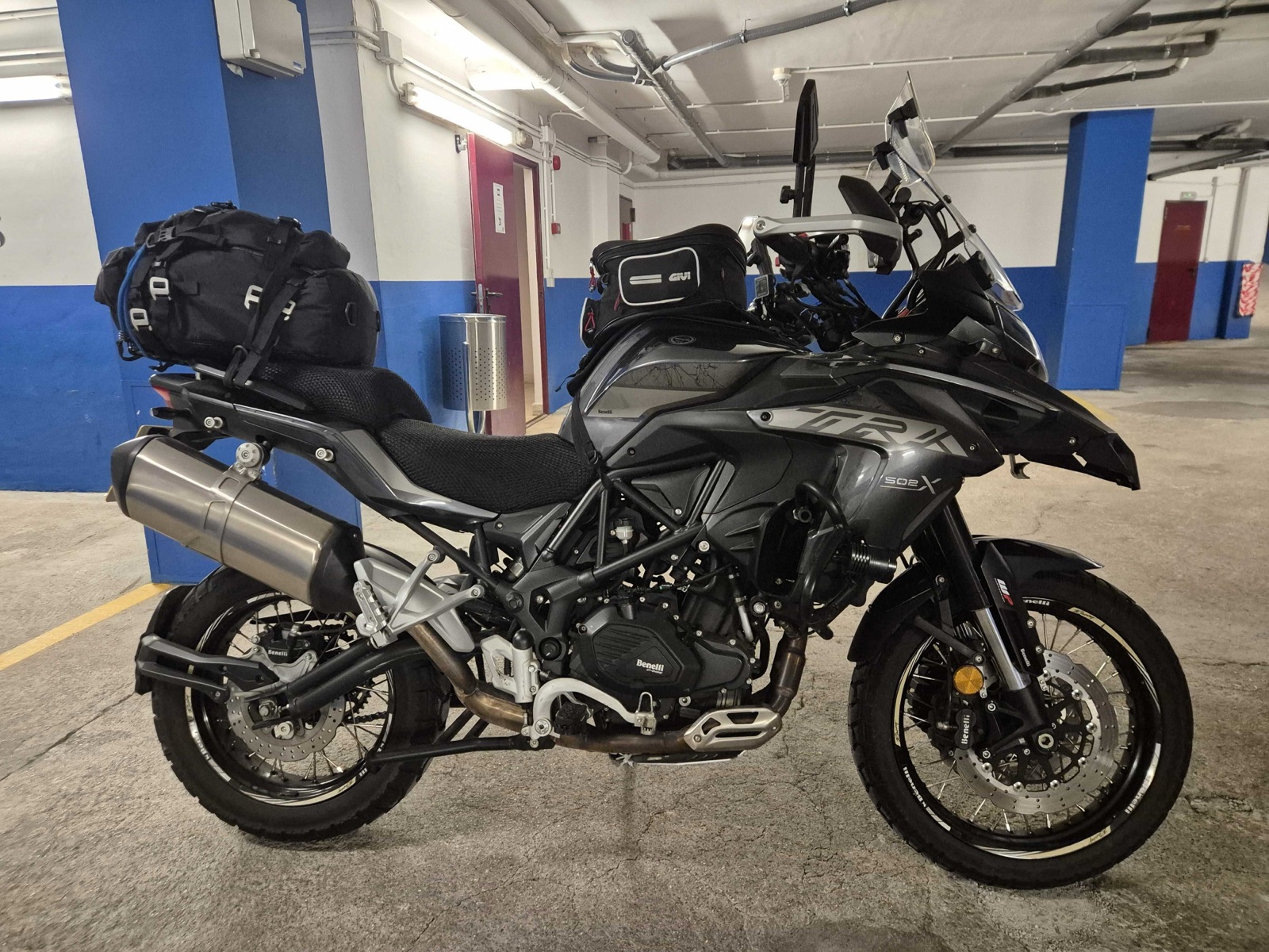 Benelli TRK 502 X side profile showing the spoked wheels, crash bars and exhaust, parked in a car park in Spain