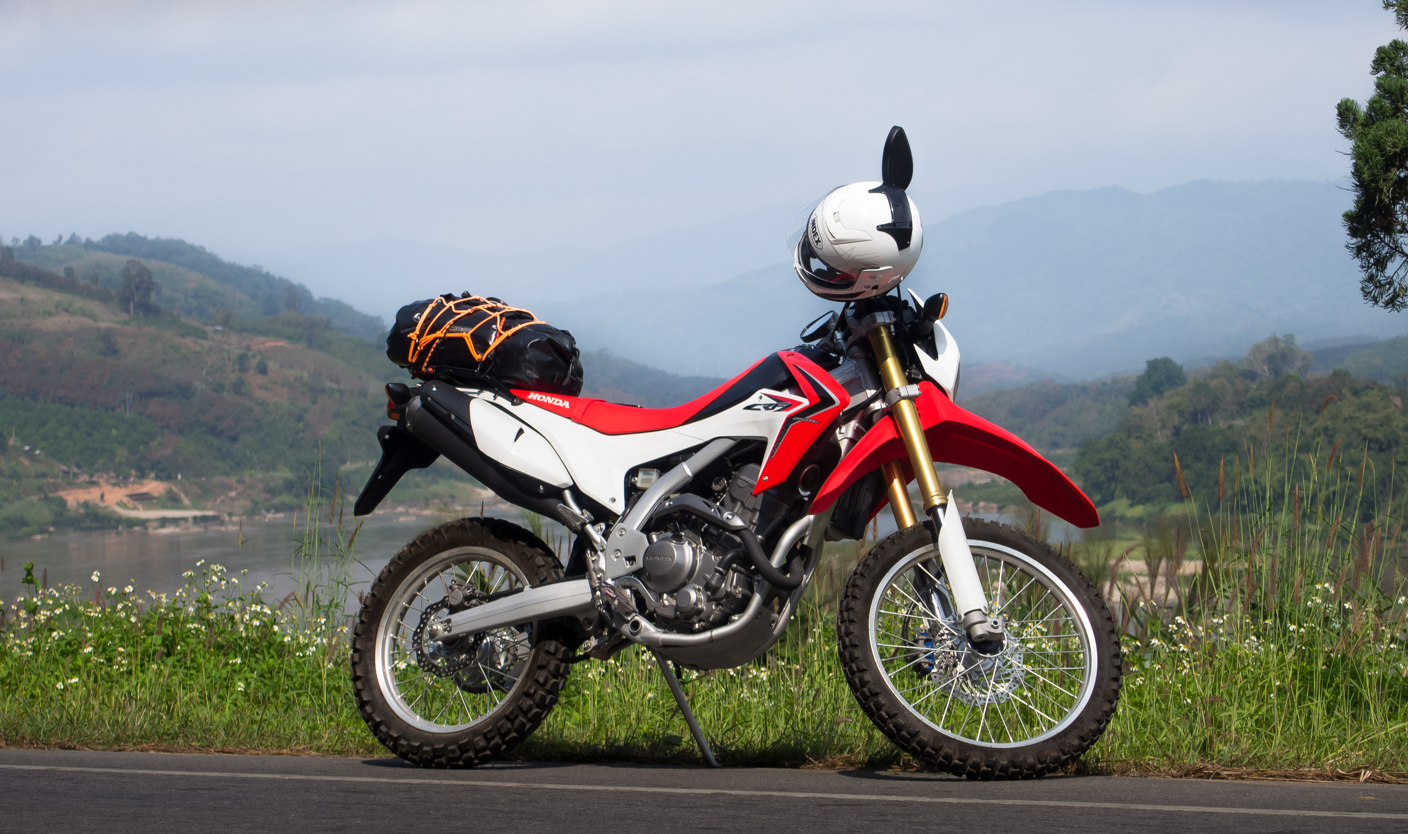 A small trail motorcycle parked on a green lane