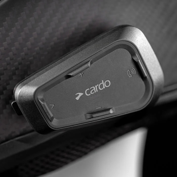A Cardo Spirit HD mounted on a carbon helmet shell