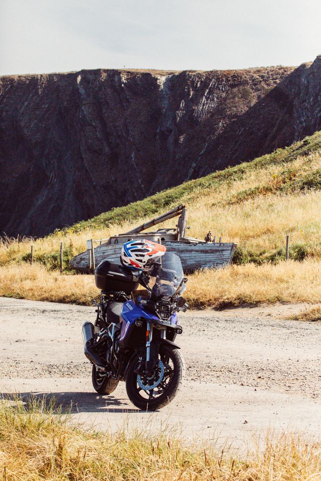 a rider stopped beside their bike taking in a view along a green lane