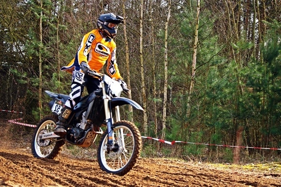 rider standing on the pegs through a rutted green lane