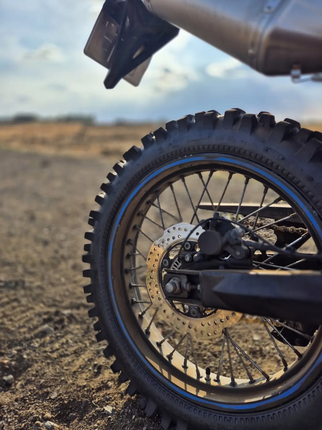 Close-up of an aggressive block-tread tyre and rear wheel on the Voge 300 Rally